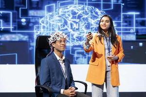 Neuroscience specialists talking at AI expo, sharing neural implants industry insights to audience. Innovative tech startup workers at tech event presenting latest AI EEG headsets photo