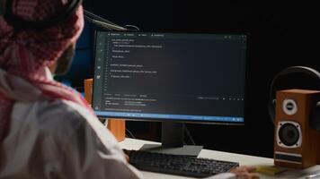 Certified arab engineer writing code on computer screen while in office using Java programming languages. Middle Eastern developer working on fixing database errors while working from apartment office photo