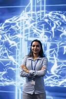Portrait of smiling IT specialist standing with arms crossed in front of cutting edge display featuring AI and neural network graphics. Researcher in startup doing advancements in AI field photo