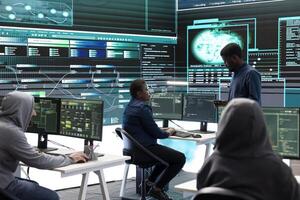 Governmental hackers using advanced software to protect against cyber threats, working in team. Specialists on cyber security, data and network protection unite forces in high tech office. photo