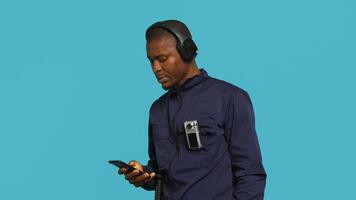 Portrait of security agent patrolling to secure assigned post, wearing bodycam, studio background. Guardian using security surveillance body camera while handling security breaches, camera A photo