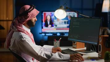 Licensed muslim engineer writing code on computer screen while in office using Java programming languages. Middle Eastern developer working on fixing database errors while working from living room photo