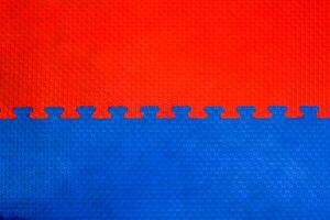 Easily interlocking puzzle shaped rubber floor mats to prevent falling shock hazards are widely used in gyms and children's rooms to prevent potential hazards. The background is a blank rubber bumper. photo