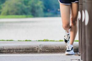 Blurred image, a young woman wears sportswear and running shoes to get ready to warm up before the training run to get ready for the next race. Training ideas to get ready for running photo