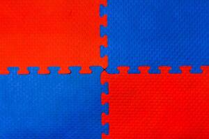 Easily interlocking puzzle shaped rubber floor mats to prevent falling shock hazards are widely used in gyms and children's rooms to prevent potential hazards. The background is a blank rubber bumper. photo