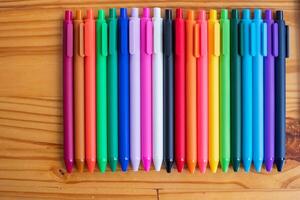 Multi-colored pens are stacked on a black desk in the designer's office in preparation for a quick and easy choice of design colors. Lots of colorful pen backgrounds for designers and designers. photo
