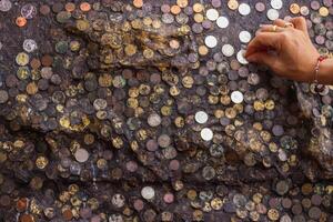 The blurry and dark background of the wall is adorned with international coins affixed to the walls of religious beliefs, and the medallions on the walls are also a blessing to God. photo