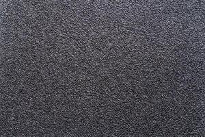 Sandpaper texture background gives a beautiful pattern of black sand grains on sandpaper, suitable as a background for inserting text. Copy Space for designers to use on sandpaper. photo
