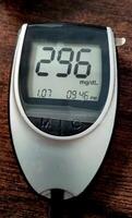 A close up of blood glucose meter with high sugar reading on wooden table photo