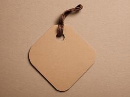 Brown Paper Price Tag With String Isolated on brown background. photo