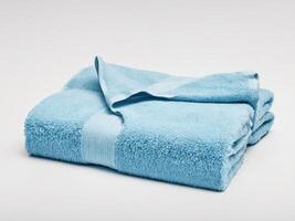 Neatly folded blue towel isolated on white background. photo