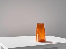 Orange paper doypack placed on podium on empty background. photo