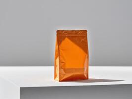 Orange paper doypack placed on podium on empty background. photo