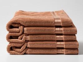 Neatly folded bronze brown towel isolated on white background. photo