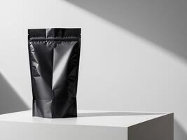 Black paper doypack placed on podium on empty background. photo