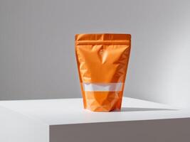 Orange paper doypack placed on podium on empty background. photo