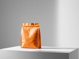 Orange paper doypack placed on podium on empty background. photo