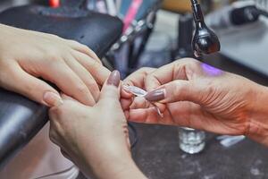 Nail Technician Applying Extension at Salon photo