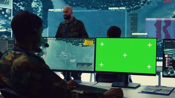 Control room operator tracking all ships anchoring along the coast line, uses isolated chromakey display in command post. Military personnel helps with real time information, reconnaissance. Camera B. photo