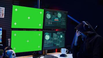 Hacker receiving access denied error message on chroma key monitors while doing corporate espionage. Scammer failing to steal information on competitor products using green screen PC, camera B photo