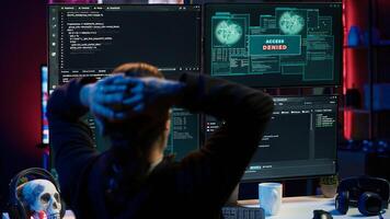 Hacker in hidden apartment trying to steal valuable data by targeting governmental websites but getting access denied error message, having cyber attacks rejected, camera A photo