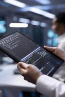 Manager in server hub using tablet to find firewall misconfigurations affecting rackmounts performance. Supervisor checking systems bottlenecks leading to sluggish data transfer rates, close up photo