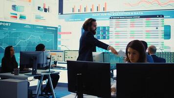 Pleased general director showing statistics data flyers to his team, proud of their organizational activity. Manager assembles with coworkers for a briefing meeting, studying sales reports. Camera B. photo