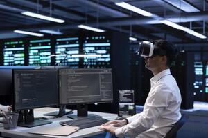 IT specialist using VR headset to do maintenance on server rows in computer network security data center. Engineer using virtual reality to do checkup on mainframes providing processing resources photo