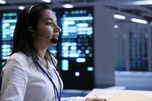 IT expert in data center providing technical support to customers, troubleshooting issues. Server room employee carrying out operational technical interventions requested by clients photo