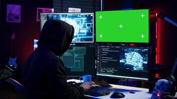 Hacker using green screen PC and AI to find unpatched connections and steal data. Scammer using artificial intelligence and chroma key computer to compromise digital devices, camera B photo
