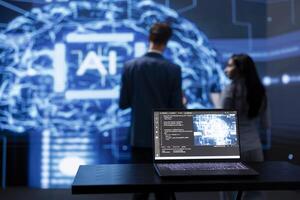 Focus on laptop running AI cognitive computing tech used by IT staff members in blurry background. Close up of notebook used by teamworking engineers to do data mining with self learning algorithms photo
