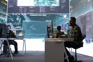 Army intelligence expert utilize advanced computer systems and satellite data to protect national security, support and maintain operational efficiency in a high tech command center military base. photo