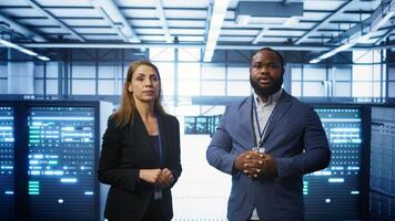 African american expert and coworker looking at holograms in data center, working together. Team members interacting with augmented reality AI visualization in server hub, camera B photo