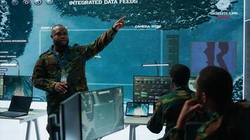 Military personnel operate advanced systems in a command center, focusing on surveillance and data analysis to protect national security. Soldiers trained to manage information warfare. Camera B. photo