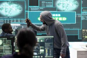 Group of professional hackers gaining access into government database to steal important information for hybrid warfare. Experts work on scams and phishing activity in high tech office. photo
