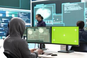 Hacking specialist works with an isolated chroma key display in high tech agency office, securing national servers with state secrets. Governmental hacker examines threat detection measures. photo