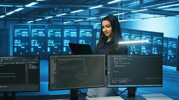 System admin working in computer network security data center, ensuring optimal performance. Worker monitoring energy consumption across operational server racks components photo