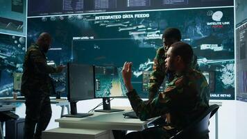 IT analyst managing satellite radar systems in modern control tower, overseeing intelligence activities and interpreting real time data. National interests for a defense mission. Camera B. photo