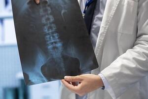 General practitioner gathering healthcare experts review x ray scans in a private clinic meeting. Licensed experts focusing on diagnostics and disease prevention, collaborative teamwork. Close up. photo