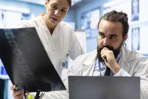 Radiologists review human anatomy scans to develop effective treatment plan. Teamwork and expertise in radiology, analytics and diagnostics ensuring comprehensive healthcare solutions. photo