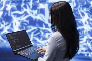 Engineer using notebook to maintenance artificial intelligence neural networks. Close up shot of IT expert using AI system aiding in processing and transmitting information photo