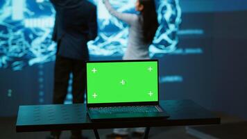 Startup coworkers using AI software on chroma key notebook to take data driven decisions. Close up of isolated screen laptop used for developing artificial intelligence solutions, camera A photo