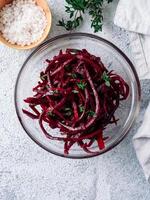 Raw beetroot noodles salad. Vegetable noodles - beet spaghetti on gray background. Copy space for text. Ideas and recipe for Clean eating, raw vegetarian food concept. Top view or flat lay. Vertical. photo