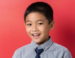 A boy looking at camera with excited face expression in front of the red background photo