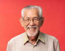 A men with 100 years old looking at the camera with excited facial expression in front of the red background photo