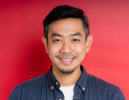 A men with 35 years old looking at the camera with excited facial expression in front of the red background photo