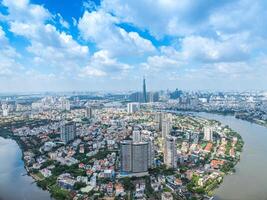 Panoramic view of Saigon, Vietnam from above at Ho Chi Minh City's central business district. Cityscape with Landmark 81 skyscraper and many buildings, local houses, rivers. photo