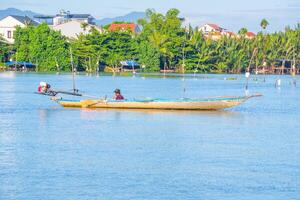 landscape of life and houses next to Thu Bon river in Hoi An ancient town, Quang Nam Province, Vietnam. Hoi An is one of the most popular destinations in Vietnam. photo