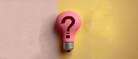 Pink Light Bulb with Question Mark on Split Pink and Yellow Background - Conceptual Image photo