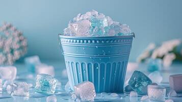 Blue Bucket Filled with Ice Cubes on a Light Blue Background with Water Droplets and Flowers photo